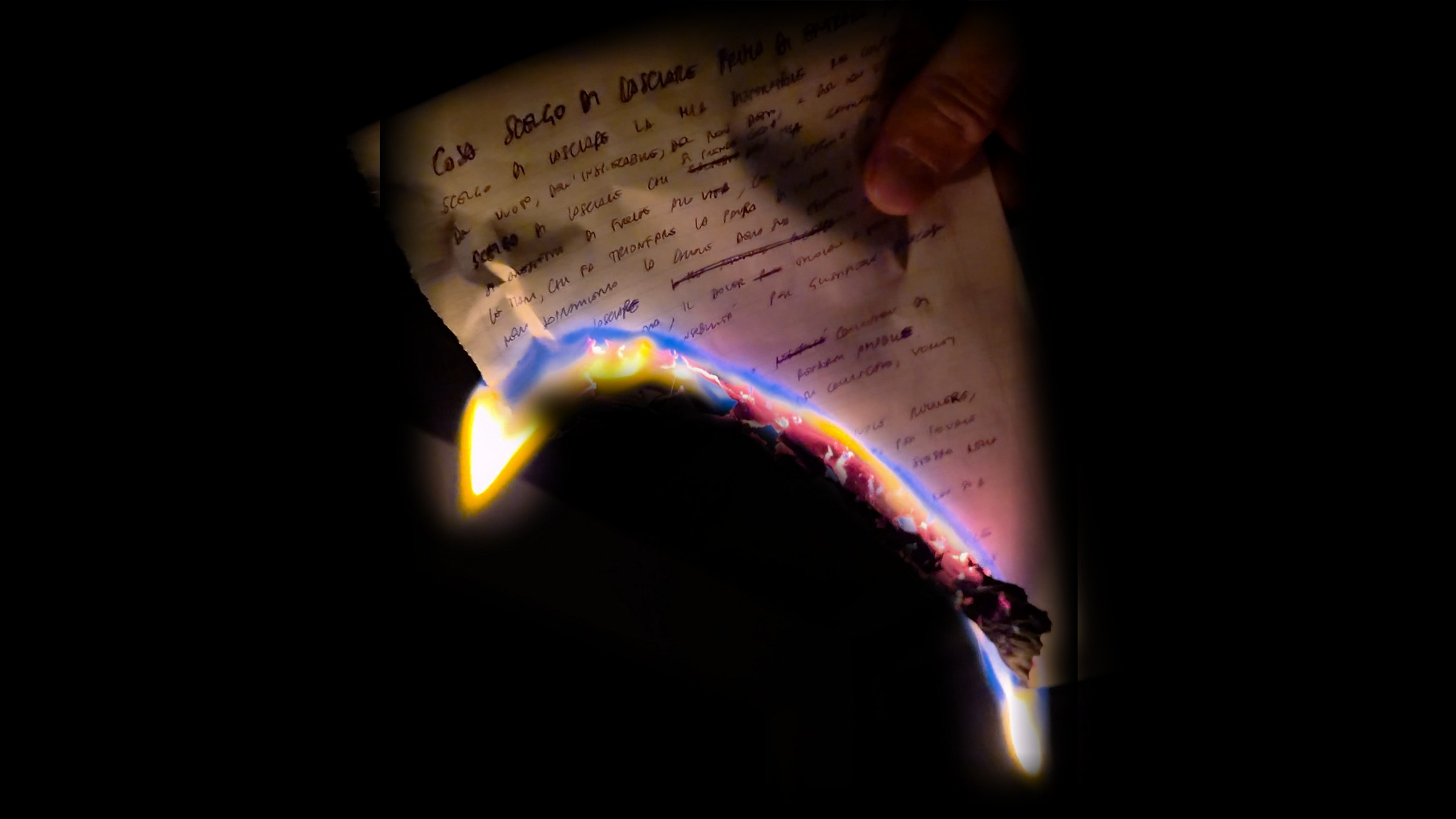 Un foglio scritto a mano, con il titolo «Cosa scelgo di lasciare prima di entrare nel buio», brucia lungo il bordo nel buio